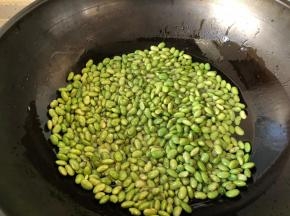 将青豆倒入油锅中小火炸