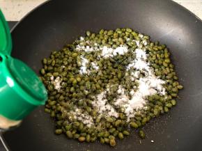 将炸好的青豆放入另外的干净锅子，小火加热，放入食盐，糖粉，大蒜粉