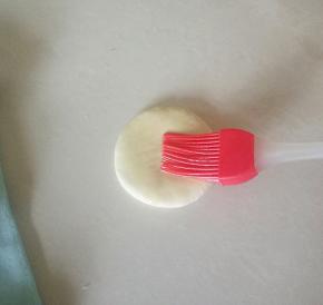 把大的面团压扁，刷上一层色拉油。