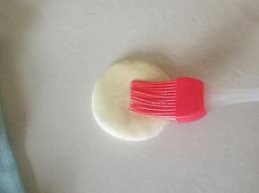 把大的面团压扁，刷上一层色拉油。