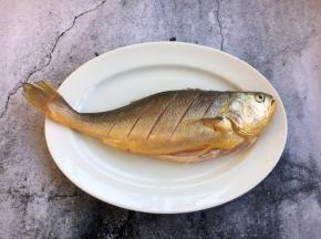 大黄鱼刮鳞，去鳃，去除内脏，清洗干净，沥干水分，把鱼的两面都打上斜刀。