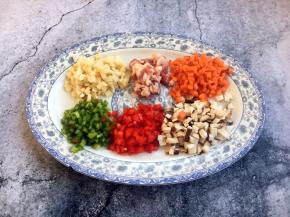 首先准备好俏菜：青红椒粒，香菇粒、冬笋（玉兰片）粒，五花肉粒、胡萝卜粒。