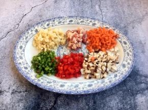 首先准备好俏菜：青红椒粒，香菇粒、冬笋（玉兰片）粒，五花肉粒、胡萝卜粒。