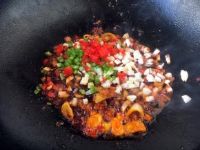 放入青红椒粒、冬笋丁、香菇丁、胡萝卜丁，翻炒均匀。