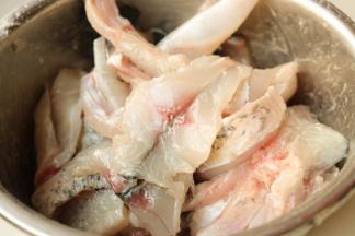 鱼肉片和鱼骨加入腌鱼料包，拌匀腌制20分钟，经过腌制的鱼肉会很滑嫩，腌制时候也可以加入一个蛋清。