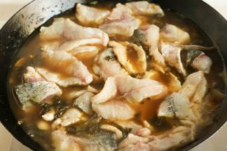 加入高汤或者水烧开，然后先放入鱼骨，再放入鱼片，要一片片放入不要黏连，放进鱼片之后就不要随意搅动了，避免鱼肉搅碎。再次煮开，煮到鱼肉变色就可以了。