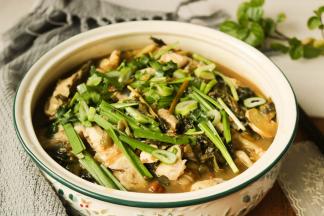 酸菜鱼这时候也做好了，先把鱼肉先盛出来放在蔬菜的上面，再倒入酸菜和汤，上面再放上韭菜和香菜，一锅酸辣鲜香的酸菜鱼就可以上桌了。