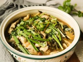 酸菜鱼这时候也做好了，先把鱼肉先盛出来放在蔬菜的上面，再倒入酸菜和汤，上面再放上韭菜和香菜，一锅酸辣鲜香的酸菜鱼就可以上桌了。