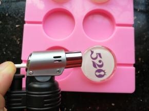 刚刚做好的棒棒糖，表面会有很多的小气泡，可以用消泡枪进行消除，这样就可以看清图案，也会更美，不介意的亲也可以不消除的，对吃没有影响。