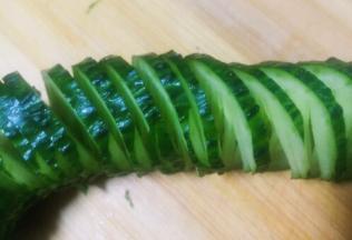 切完后整条黄瓜不断开，如图这样很有收缩性，像拉花一样
