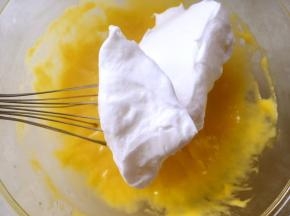 将打发好的蛋白分次加入到蛋黄糊中翻拌均匀，可以先用蛋抽翻拌，最后再用刮棒将底下翻拌不到的翻拌均匀