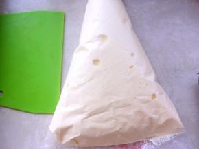 将翻拌好的面糊装入裱花袋，可以将裱花袋套在杯子上，之后用刮板排除空气