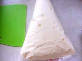 将翻拌好的面糊装入裱花袋，可以将裱花袋套在杯子上，之后用刮板排除空气