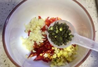 把两种辣椒任意切碎，老姜大蒜剁末装在一个碗里，放入30左右的青花椒粒