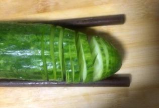 然后反转180度，同样用筷子垫在黄瓜底部，正常切的方式，同样也是在筷子处止刀