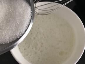 蛋清里加入2滴白醋或柠檬汁，打发至鱼眼大泡状，加入第一次白糖（60g糖分三次加入）继续打发