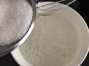 蛋清里加入2滴白醋或柠檬汁，打发至鱼眼大泡状，加入第一次白糖（60g糖分三次加入）继续打发