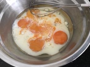 蛋黄里加入玉米油，纯牛奶，搅拌均匀至蛋液油奶完全融合