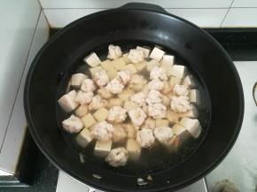 水开之后，用手把鱼泥挤成丸子，放入锅中。