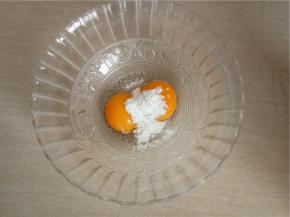 将柠檬汁、细砂糖倒入蛋黄中。