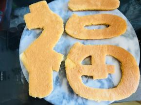 蛋糕烤两个，因为要做两层。把你想要的图案用纸打印出来，或者用油纸拓下来。按照所要的字体，将蛋糕裁好。
