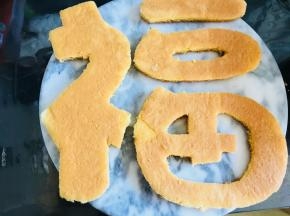 蛋糕烤两个，因为要做两层。把你想要的图案用纸打印出来，或者用油纸拓下来。按照所要的字体，将蛋糕裁好。