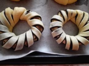 烤盘上铺上油纸，将整好形的面包放在上面，