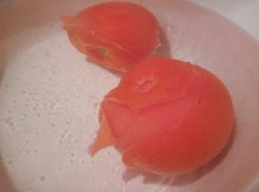 番茄切“十”子花刀，放入热水浸泡，泡至番茄开裂，去皮，切小块