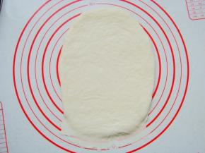 取一个面团擀成长条薄面片，末端压薄（利于封口）