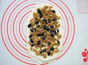 铺上提前泡软的葡萄干和黑加仑，轻轻按几下。