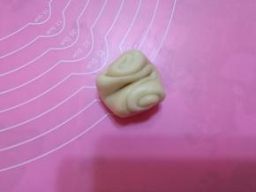 取第一个面团，中间用手指压一下，两头对折。