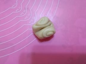 取第一个面团，中间用手指压一下，两头对折。