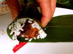 从有糯米的一头向另一头卷起，如图