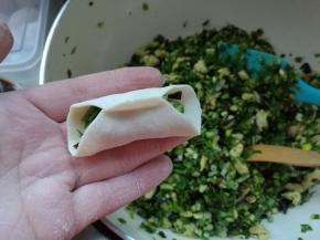 取一个饺子皮放在手上，先把中间捏一下。