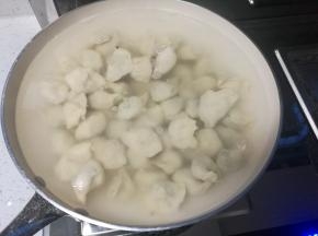 锅开后下入饺子煮熟，素馅容易煮，翻两个滚就好了