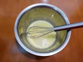 将牛奶倒入装蛋黄的盆里。
搅拌均匀。