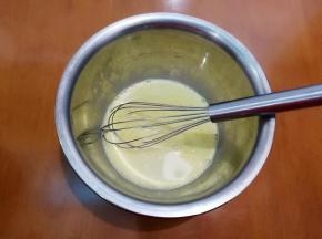 将牛奶倒入装蛋黄的盆里。
搅拌均匀。