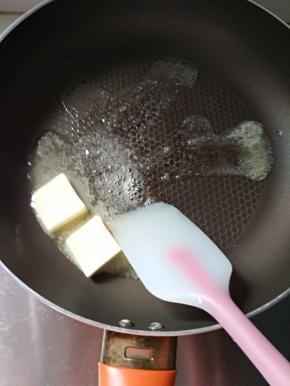 4.黄油放入不粘锅融化，燃气灶开小火，注意一定是小火，小火，小火，重要的事情说三遍！火大了糖浆会老，做出来的牛轧糖就死硬死硬的。