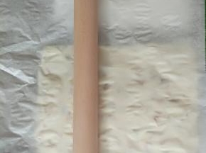 13.最后用擀面杖，铺上一张油纸，在糖上面轻轻擀几下，轻轻的哦，不然压实了等下糖粘住了烤盘挖不起来了。亲身经验～告诉小伙伴们哈！