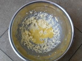 将蛋液分次加入打发后的黄油中，每次加入后用打蛋器搅打均匀后再加入下一次蛋液