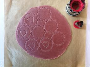 用饼干模具压出花型，移除多余面片后重新揉成团后擀开再压模，共压出16片，将其中8片用爱心切模挖出爱心形状