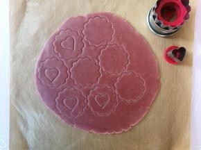 用饼干模具压出花型，移除多余面片后重新揉成团后擀开再压模，共压出16片，将其中8片用爱心切模挖出爱心形状