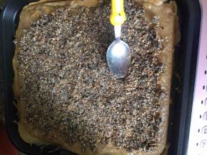 均匀地铺上馅料（熟花生碎、白芝麻和黑芝麻、炒香后拌白糖而成）用汤匙压实。