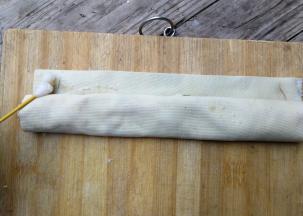 从一边卷起来留下两厘米，用棉签沾食用碱水涂抹一下