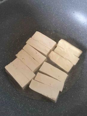 豆腐切小条入锅煎。