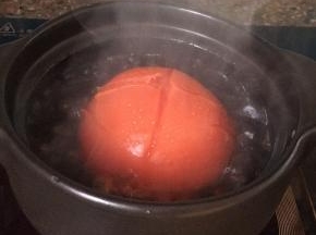 番茄洗净去蒂头，在上面画十字，放入煮沸的水中煮一小会儿。