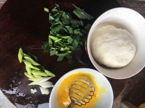 面粉里加一点盐，和清水揉成不粘手的面团。青蒜洗净切段，鸡蛋液加少许盐打匀。