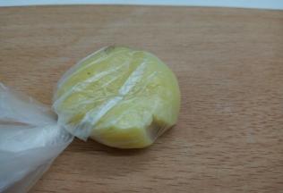 土豆装入保鲜袋，攥紧，用刀背轻轻敲扁