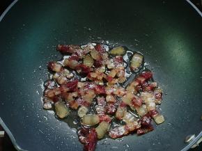 放入腊肉炒至透明，加少许料酒