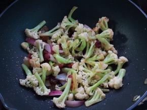加入洋葱炒出香味后倒入菜花翻炒几下
